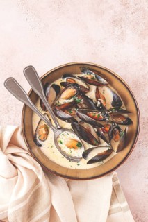 Mussels in creamy garlic sauce, served with fresh herbs and spices, homemade, no people