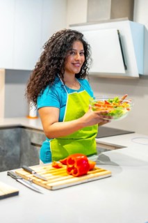 Vertical photo of a latin attractive woman recording a video blog teaching how to prepare healthy
