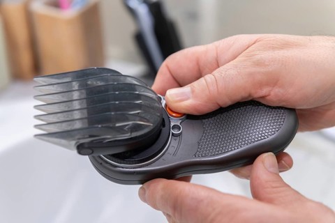 Close-up of hands adjusting a hair clipper, emphasizing precision and control. Ideal for barbershop