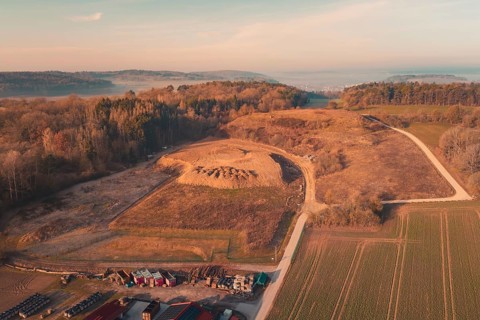 Aerial view of a landscape with hills and forests surrounded by fields and small villages in