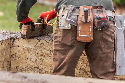 Construction Worker Leveling Wet Cement Into Wood Framing