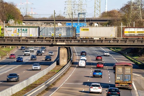 Freight train crosses the A42 motorway at Oberhausen-Zentrum on a railway bridge, the railway line