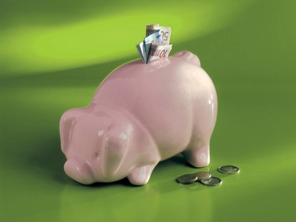 Piggy bank with banknotes on green background, Bavaria, Germany
