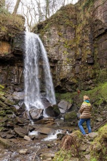 Woman looking at waterfall, Melincourt Waterfalls Nature Reserve, Melincourt, Neath, Wales, United