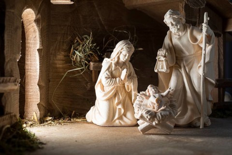 The Holy Family at the crib, wooden crib figurines represent the birth of Jesus Christ Child lying