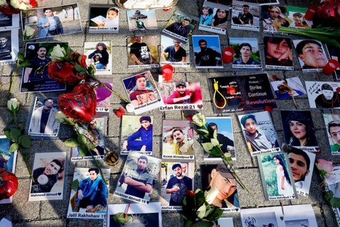 Photos of murdered Iranians who died during the protests in Iran lie during a demonstration against