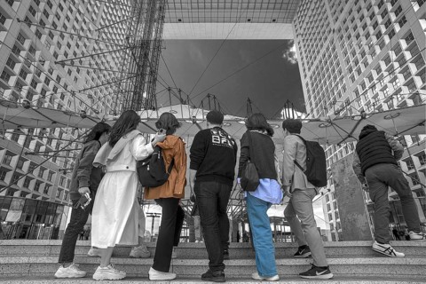 Tourists take a souvenir photo in the Grand Arche, La Défence, the New High City Quarter, black and