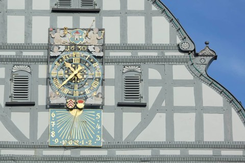 Grey tail gable with clock, sundial, city coat of arms and date 1630, shutters, decorations,