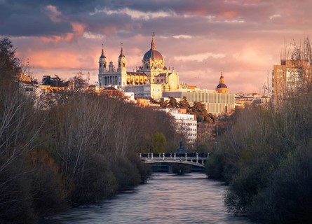 Captivating sunset view of the majestic Almudena Cathedral of Madrid bathed in warm hues, set
