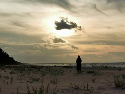 A silhouette of a person on the beach at sunset with dramatic sky, fresh spit, Baltic Sea, Poland