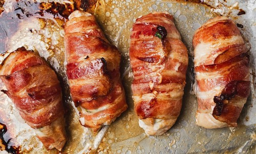 Baked chicken breast, wrapped in bacon, on a baking tray. in the home kitchen.close-up