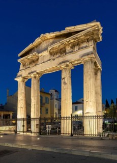 Gate of Athena Archegetis illuminated against the blue night sky, Roman Agora, Athens, Greece