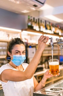 Photo session with a waitress with a face mask in a bar. New normality, security measures after the