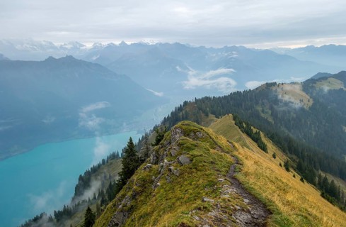 A breathtaking early morning view from a high mountain trail overlooking a turquoise lake