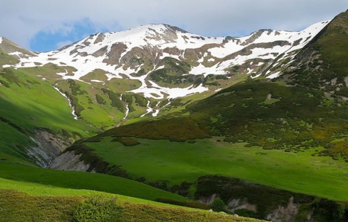 Green mountain landscape with snow and clouds in the sky, Zagari Pass, Svaneti, Greater Caucasus,