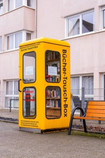 Yellow book exchange box in front of a residential building. Inviting for passers-by, Großbottwar,