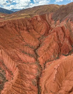 Eroded mountain landscape, canyon with red and orange rock formations, aerial view, Konorchek