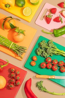 A colorful array of fresh fruits and vegetables displayed on vibrant cutting boards. Includes