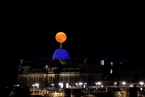 Glowing strawberry moon on 11 June 2025 over the Dresden University of the Arts, Saxony, Germany
