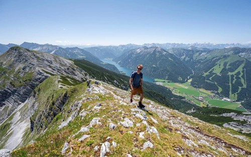 Mountaineer on the summit ridge of the Unnütz, behind Achensee and summit of the Seekarspitze
