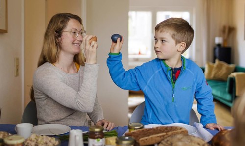 Family at Easter breakfast with Easter eggs, Bonn, 31.03.2024. Mother and son play a game called