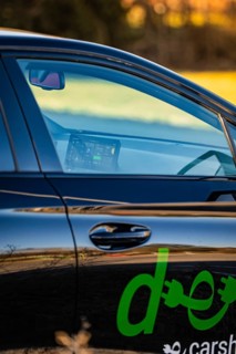 The interior of an electric car with visible screen and reflections, Deer E- Carsharing vehicle