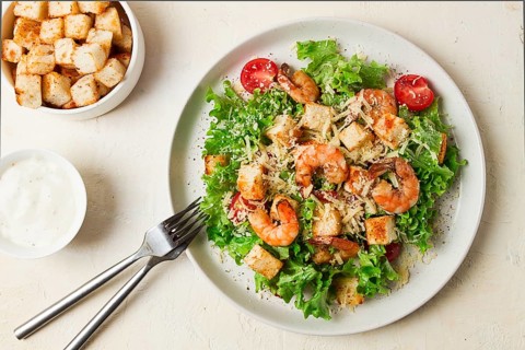 Caesar salad, with shrimp, on a white background, homemade, no people