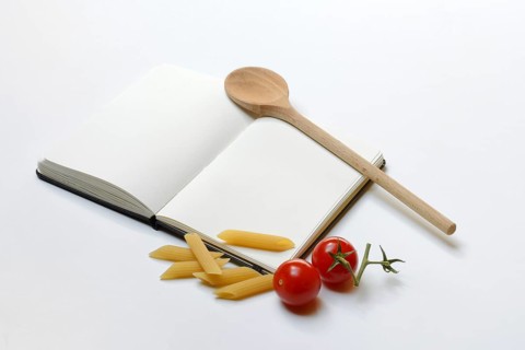 Notebook for recipes, cooking spoons, pasta and tomatoes