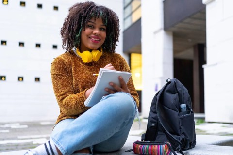 Portrait of black ethnic girl sitting in college doing class work