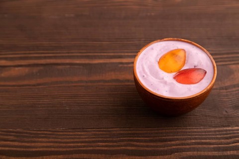 Purple Yogurt, with jelly candy on brown wooden background, side view, copy space, minimalism