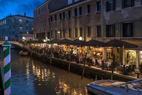 In the evening, illuminated restaurant on the canal, Venice, Veneto. italy