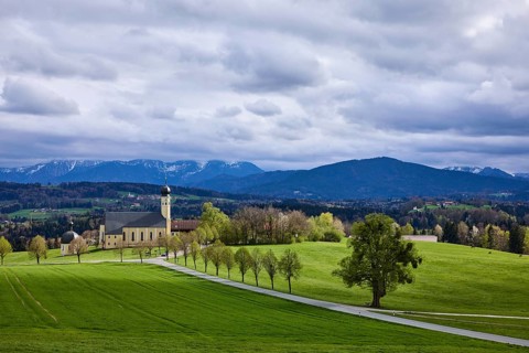 Pilgrimage church Wilparting St. Marinus, mountain landscape, meadow, trees, road, snow-covered