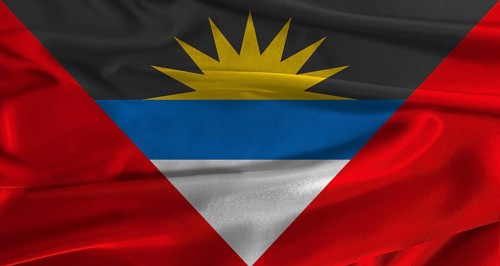 Flag of Antigua and Barbuda with fabric textured background. Close up of National flag of Antigua