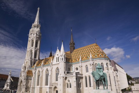 Saint-Mathias church with orange ceramic tiled rooftop and Stephen the 1st statue, Budapest,