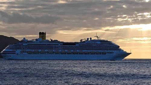 Large cruise ship, Costa Favolosa, on the sea at sunset with atmospheric clouds, Mindelo, Sao
