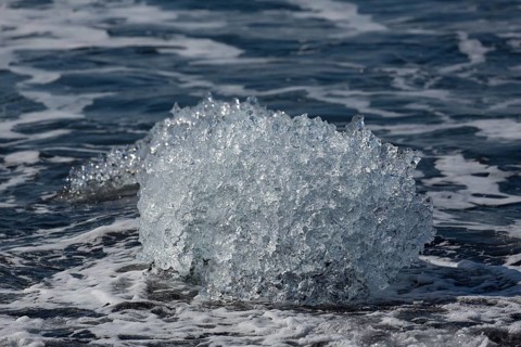 Little icebergs and crushed ice on the black beach at Joekulsarlon glacial lake