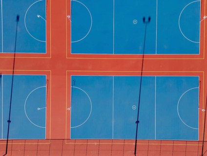 Top view captured by drone showcasing multiple vibrant netball courts in Canberra. The image