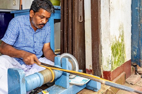 A worker in a workshop works with a rod on a grinding machine, The gemstone cutters in the city of