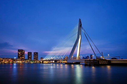 Erasmus Bridge (Erasmusbrug) and Rotterdam skyline illuminated at night. Rotterdam, Netherlands