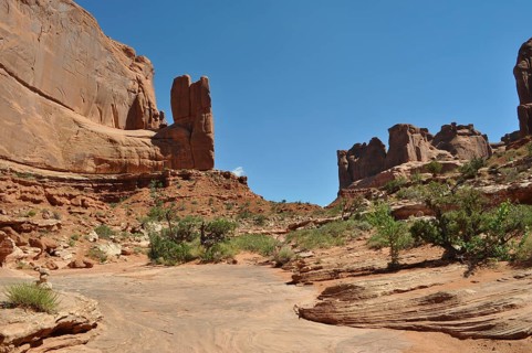 Red rock landscape with clear sky and sparse vegetation, Arches National Park, Utah, USA