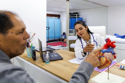 Young female doctor provides professional care to an elderly male patient in a Latin American