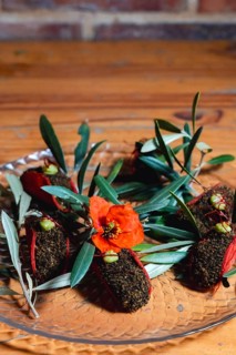 A creative tomato taco adorned with rich olive soil and vibrant garnishes. This inventive dish