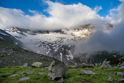 Cloudy mountain landscape, view of rocky and glaciated mountains with summits Hoher Weißzint and