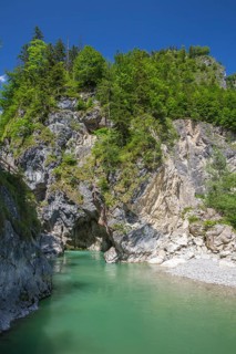 The Lammer creek is flowing fast through the Lammerklamm on a sunny hiking day. Blue sky, turquoise