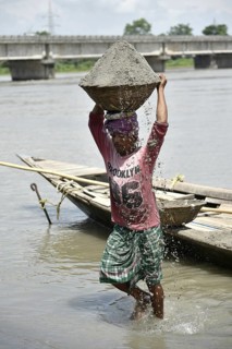 Labourer carries extracted sand from Beki River, in Barpeta district in Assam, India on Sunday