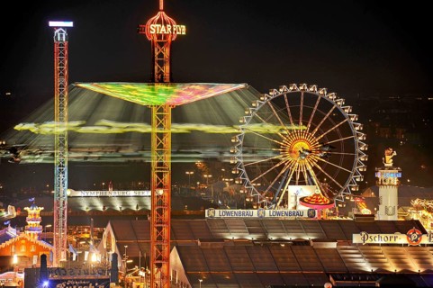 View over the Wies'n at night with illuminated carousel, Ferris wheel, stalls, beer tents and