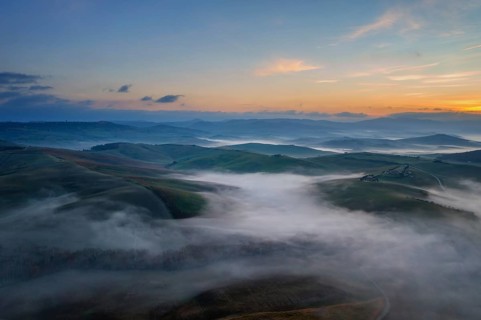 A stunning aerial view of the Val d Orcia in Tuscany, Italy, with rolling hills blanketed in