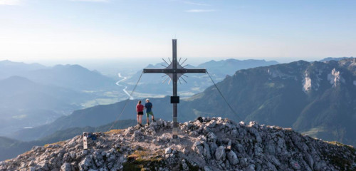 Two hikers at the summit, aerial view, evening mood in the mountains, summit cross of the