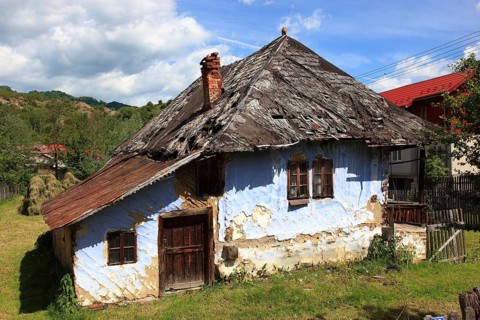 Traditional Romanian farmhouse that is in a dilapidated or abandoned state. The eye-catching light