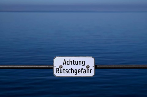 SIGN ATTENTION RUTSCHGEFHAR, behind it water, lake, Bregenz, Vorarlberg, Lake Constance, Austria